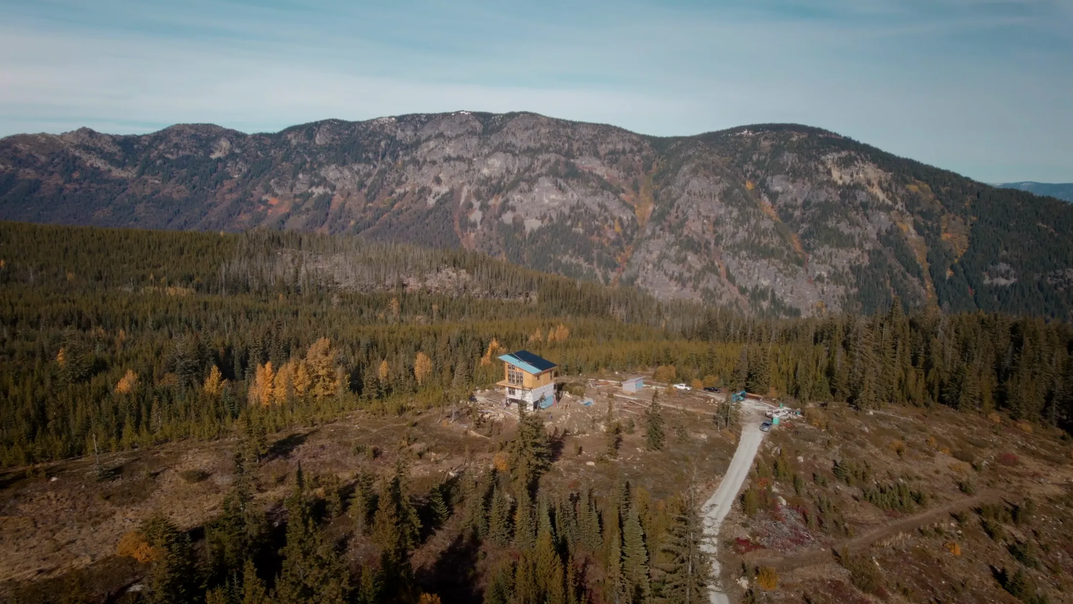 Aerial of forested ridges and a mountain beyond