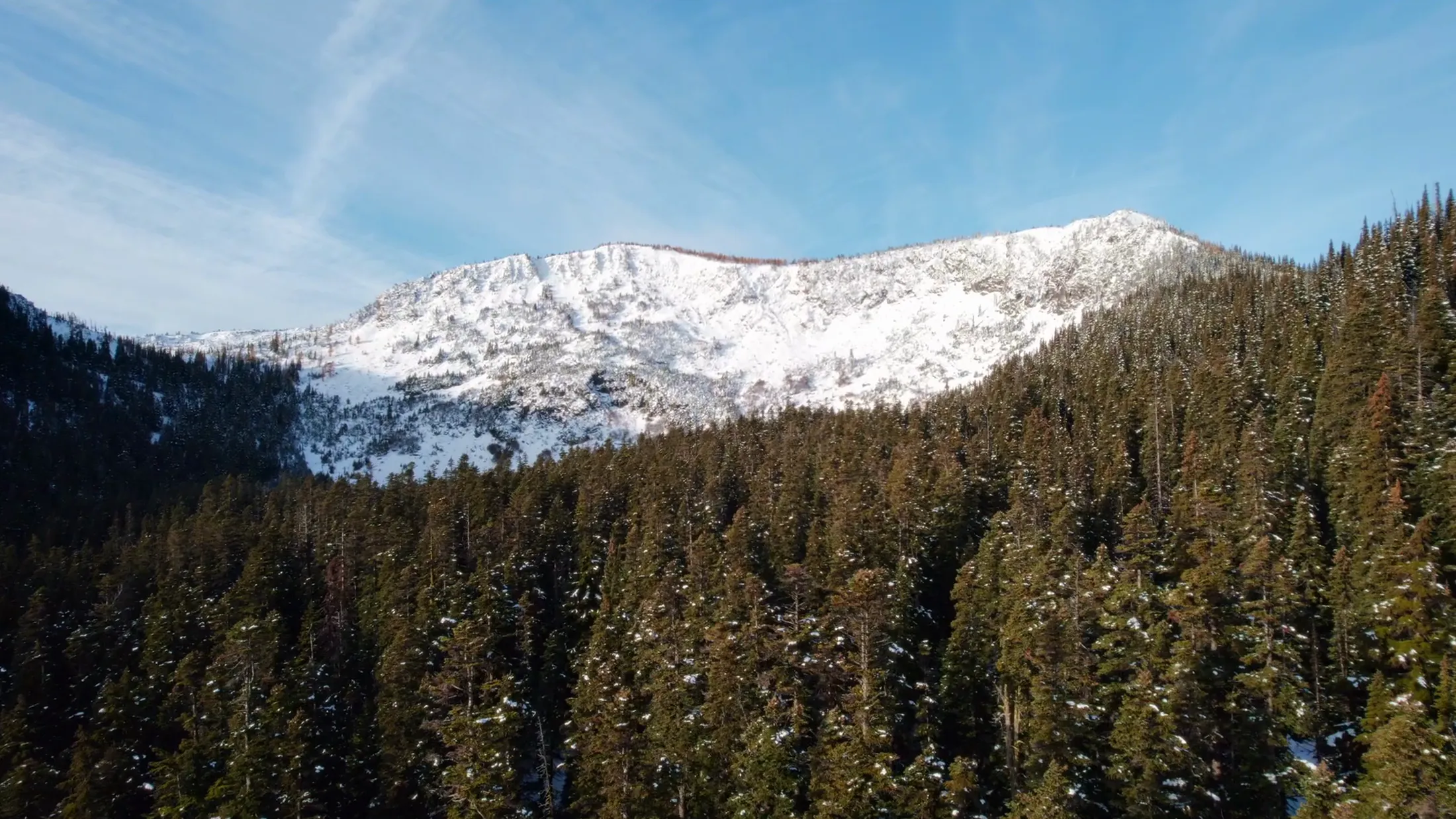 Aerial of a snowy summit under blue sky
