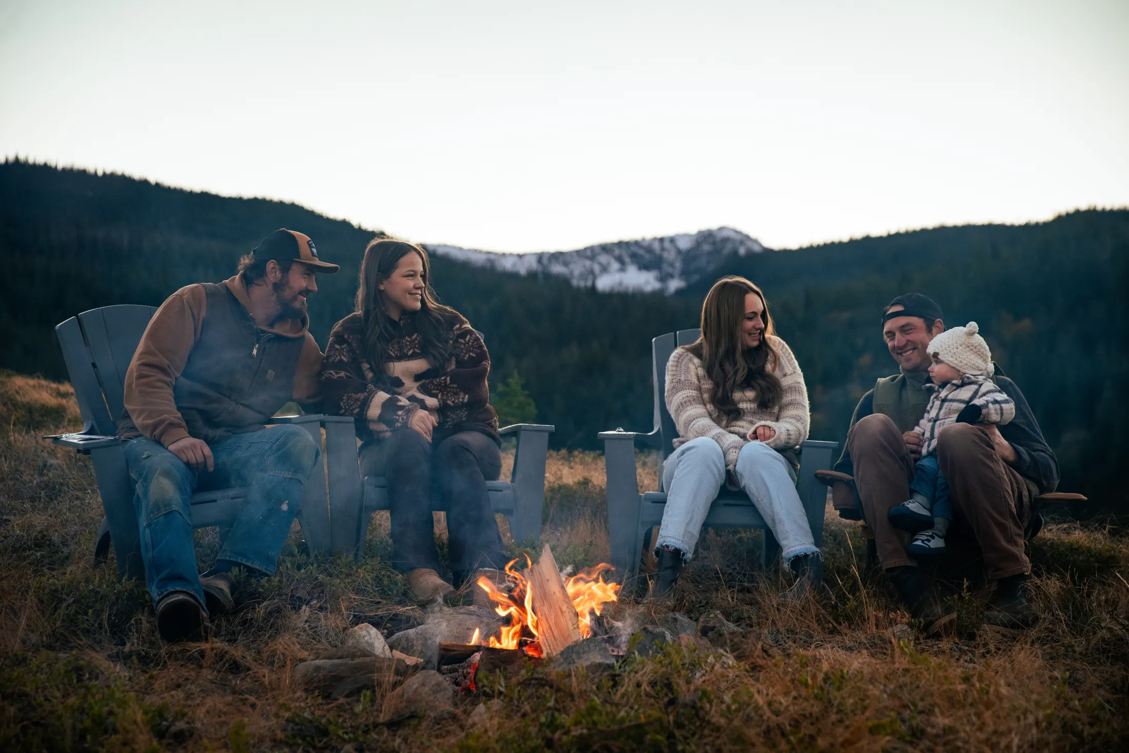 Family gathered around a campfire at sunset