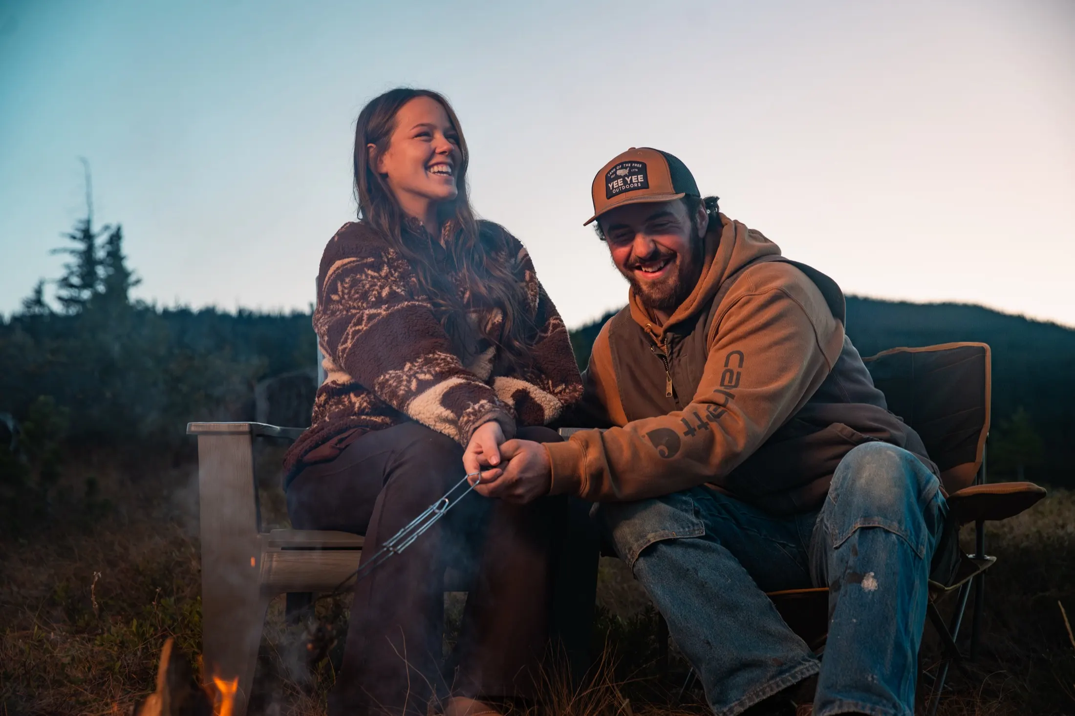 A couple sitting by the fire at dusk