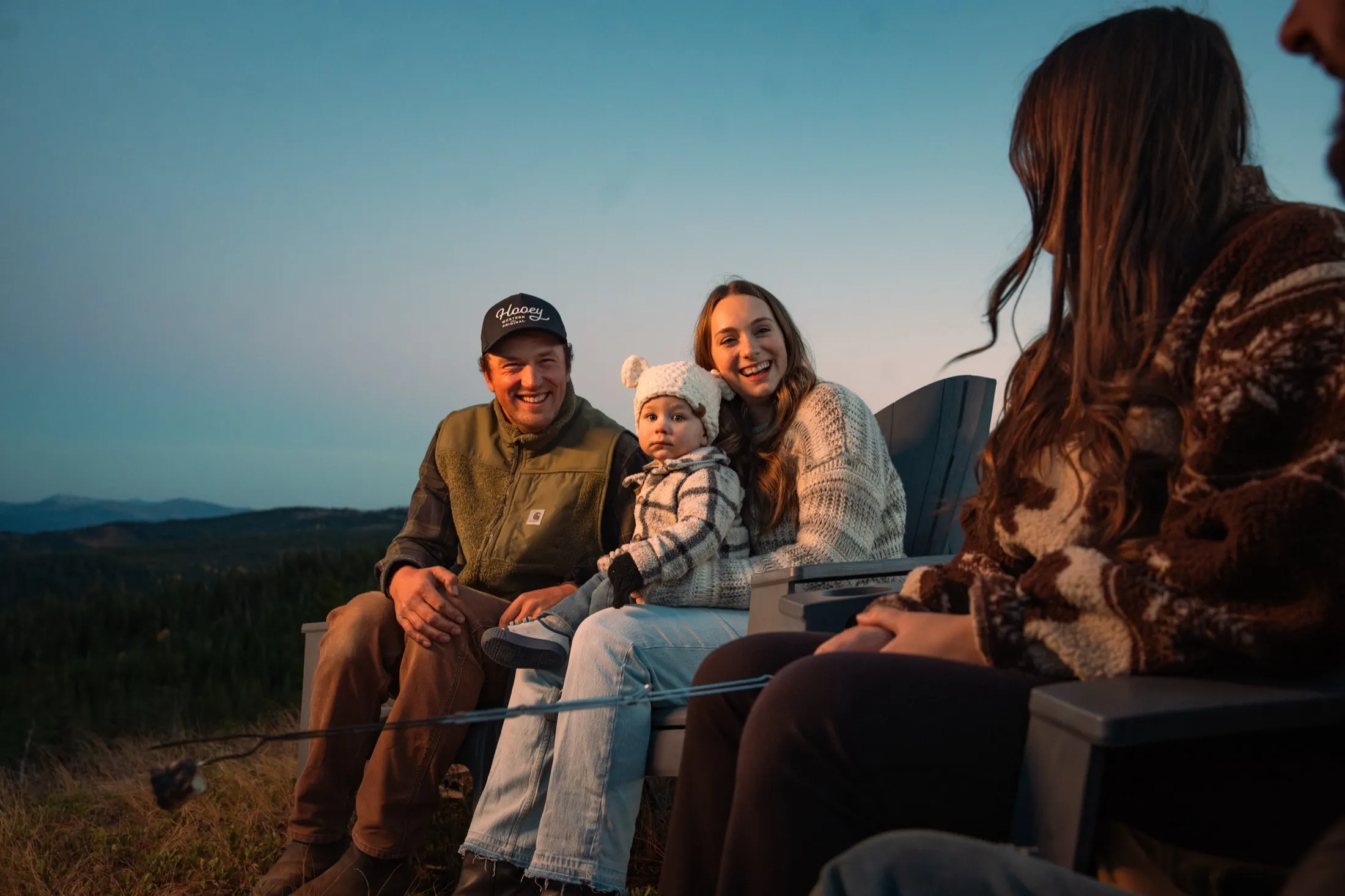 Family around the fire as the sky fades