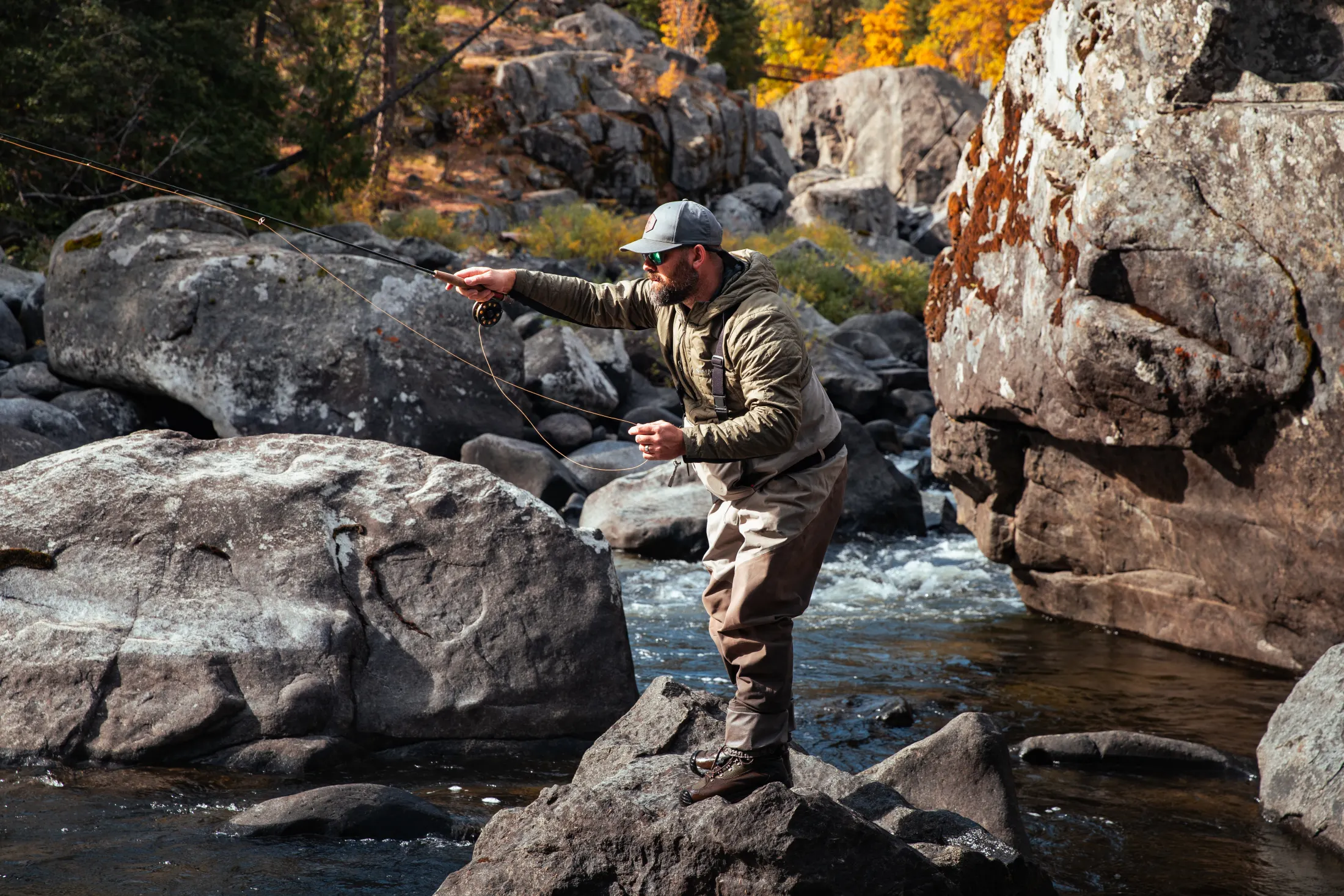 Angler casting from the rocks of a mountain river