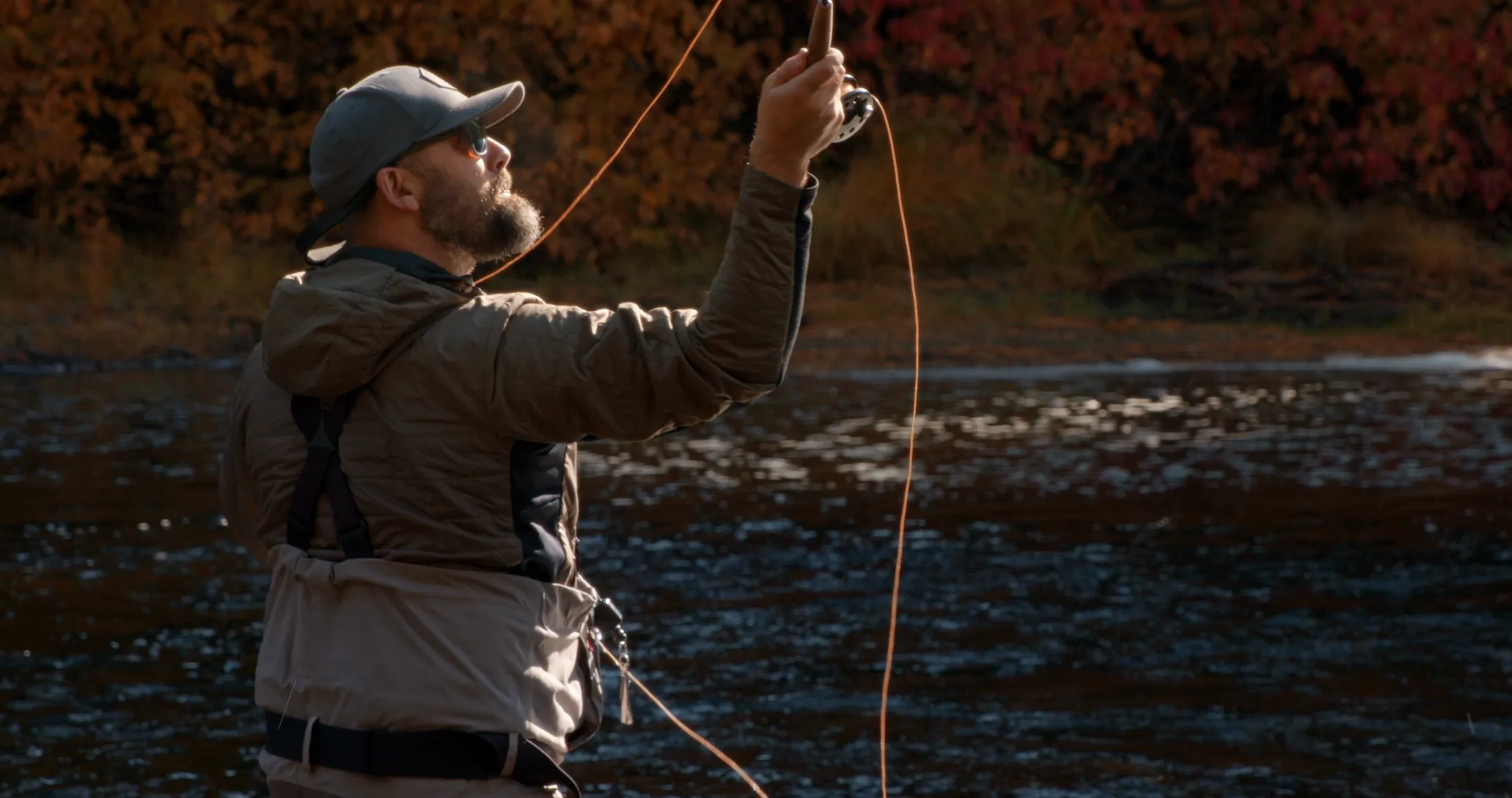 Fly fisherman casting in low sun