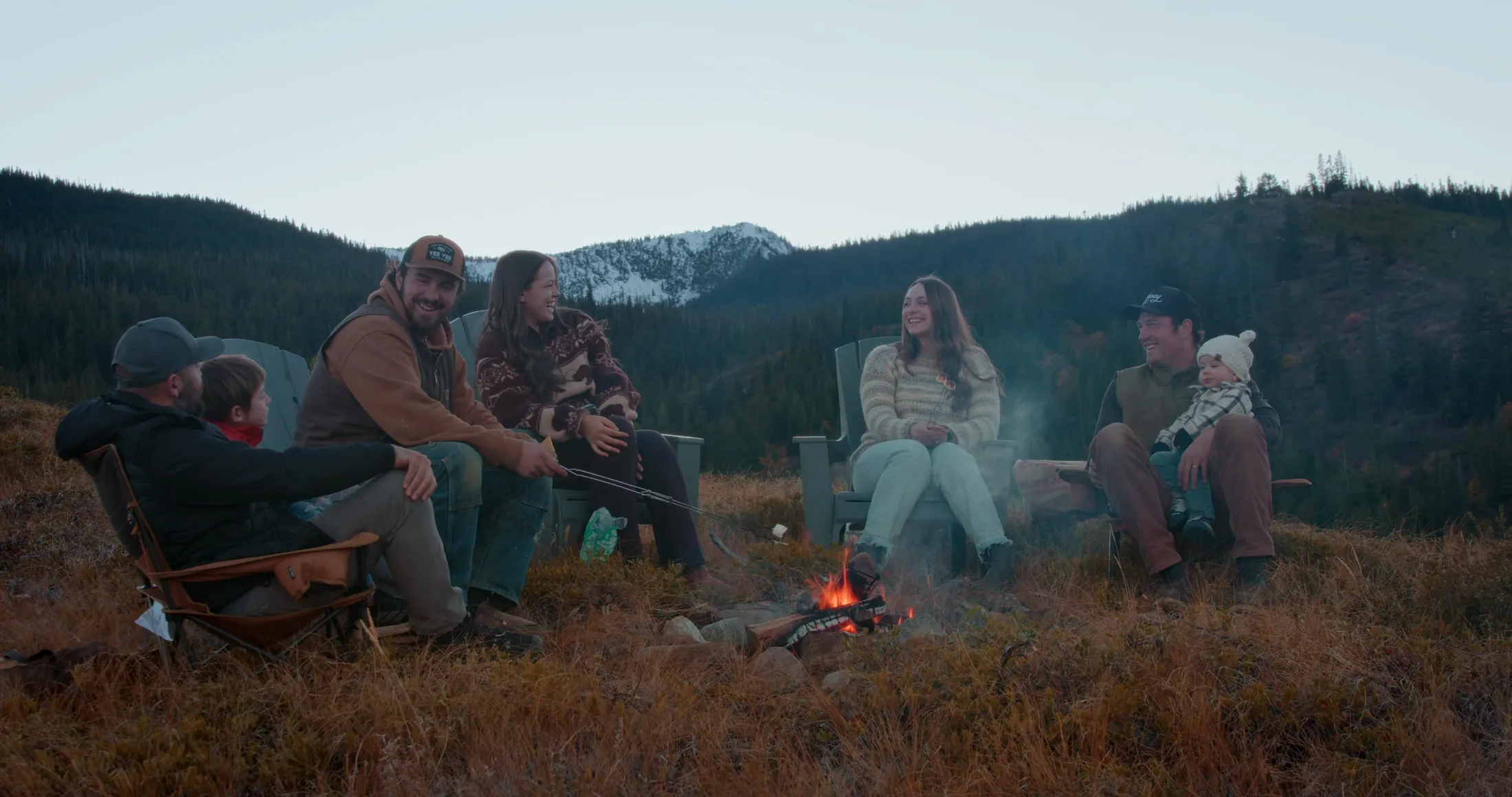 Friends around a campfire on an open ridge