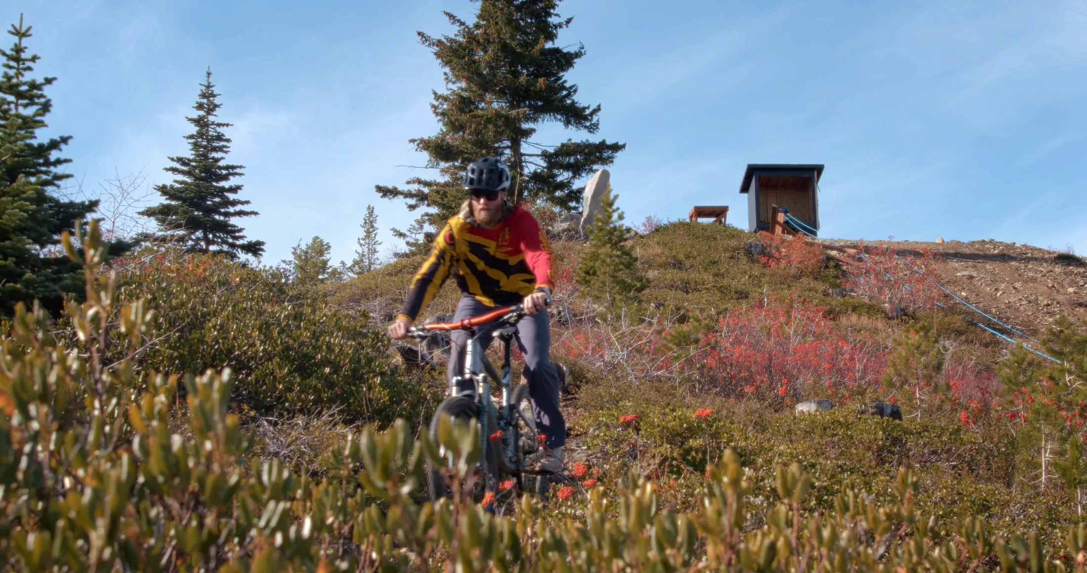 Mountain biker on a ridge trail near a hut