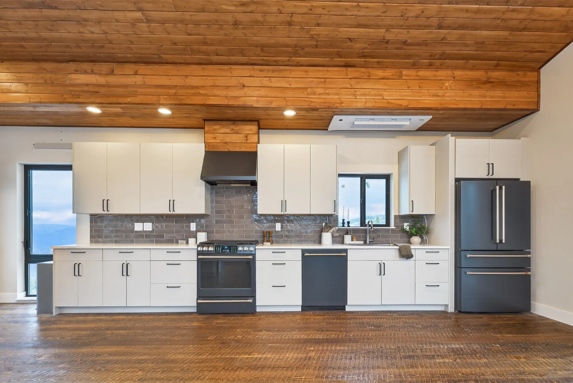 Kitchen with white cabinets under a wood ceiling