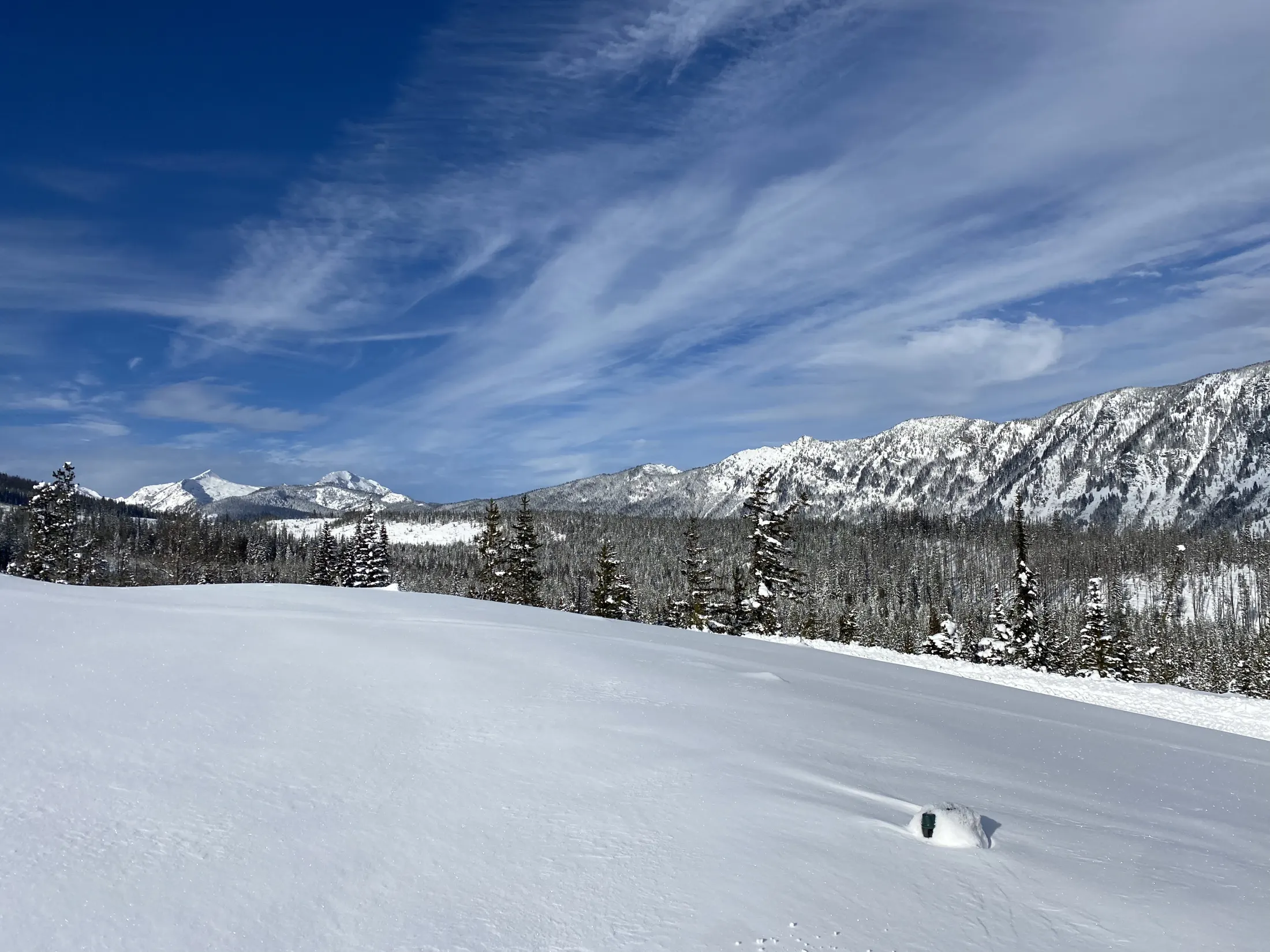 Snowfield and distant peaks under a big sky