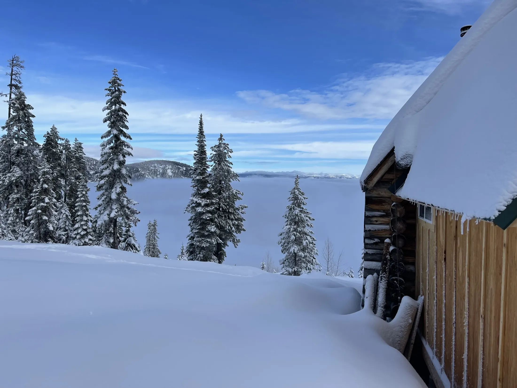 Snow piled on a cabin roof above the clouds