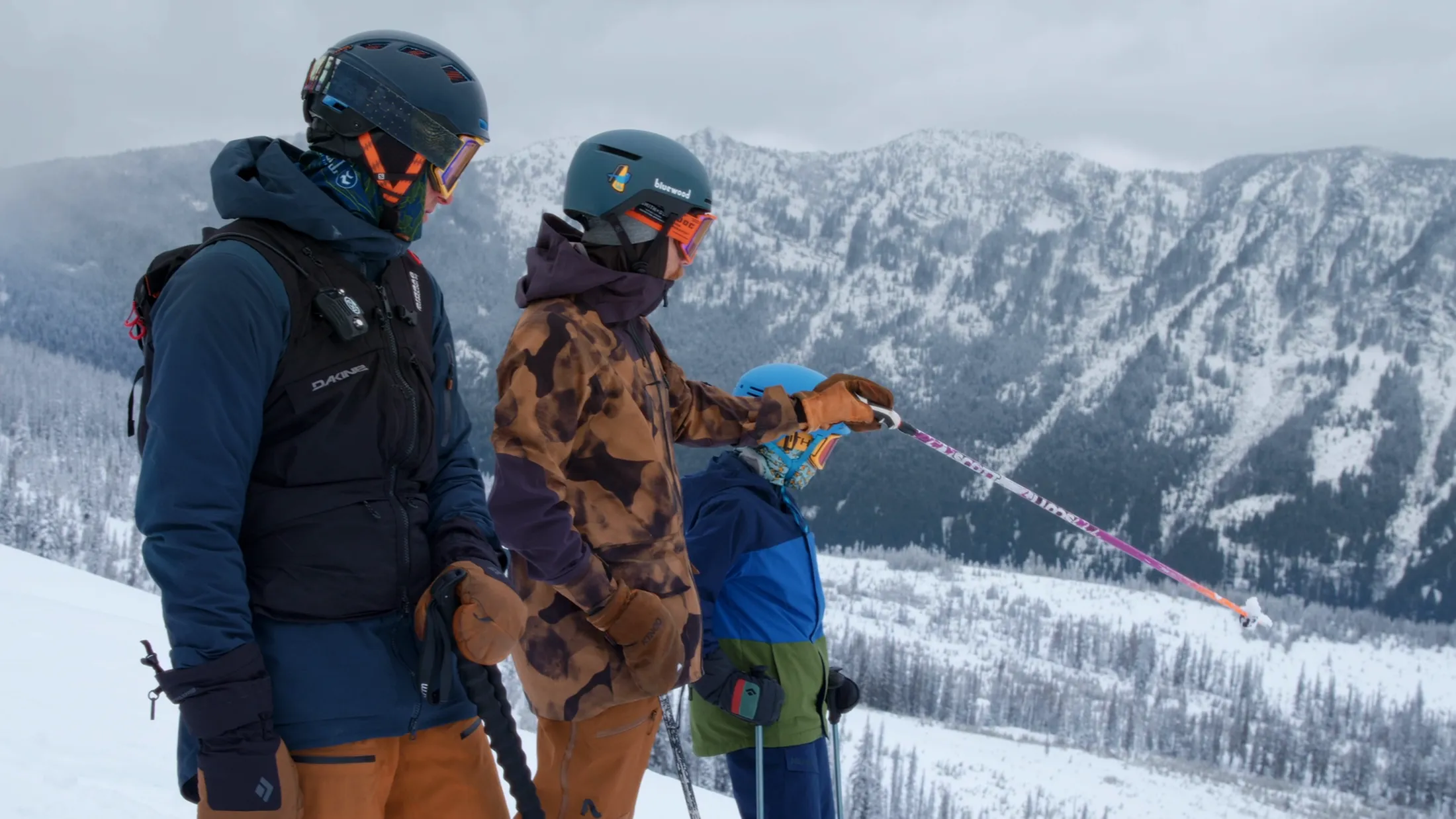 Kids in ski gear looking out over snowy peaks