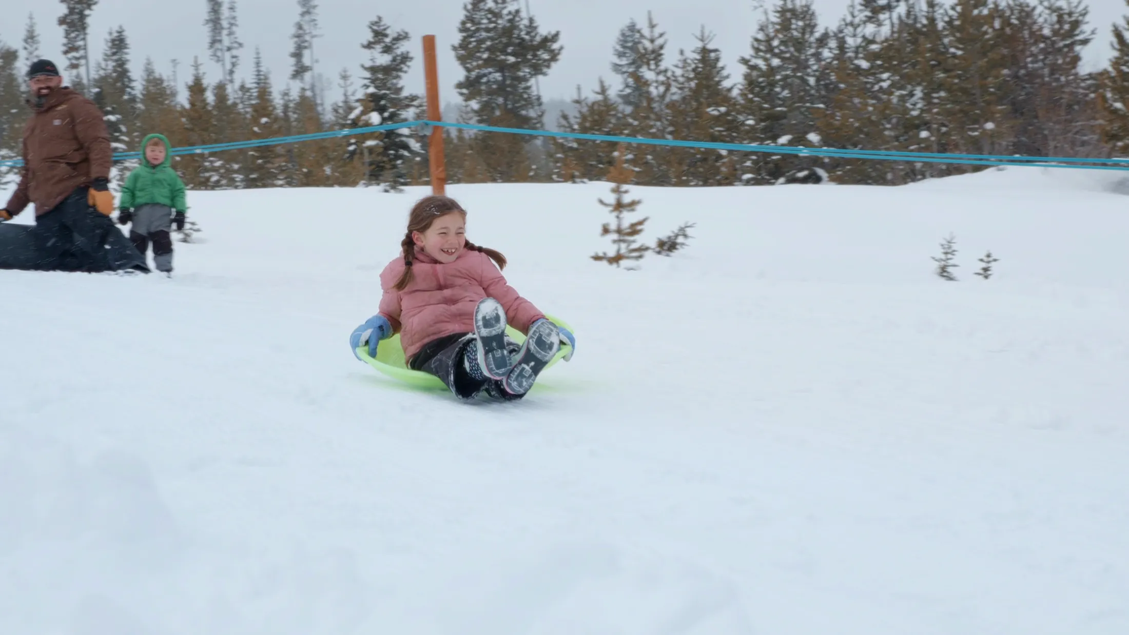 Child sliding down a snowy hill on a sled