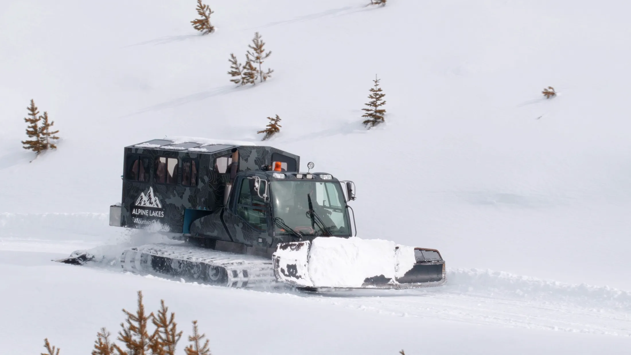 Snowcat plowing through deep powder